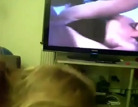 Mom gives son head while he watches porn